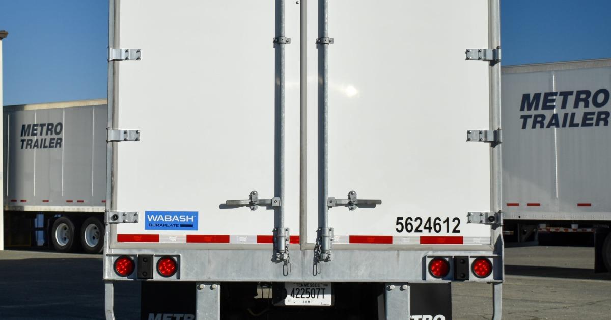 A close-up of the back side of a Metro Trailer semi trailer. There are two latches, one on each door.