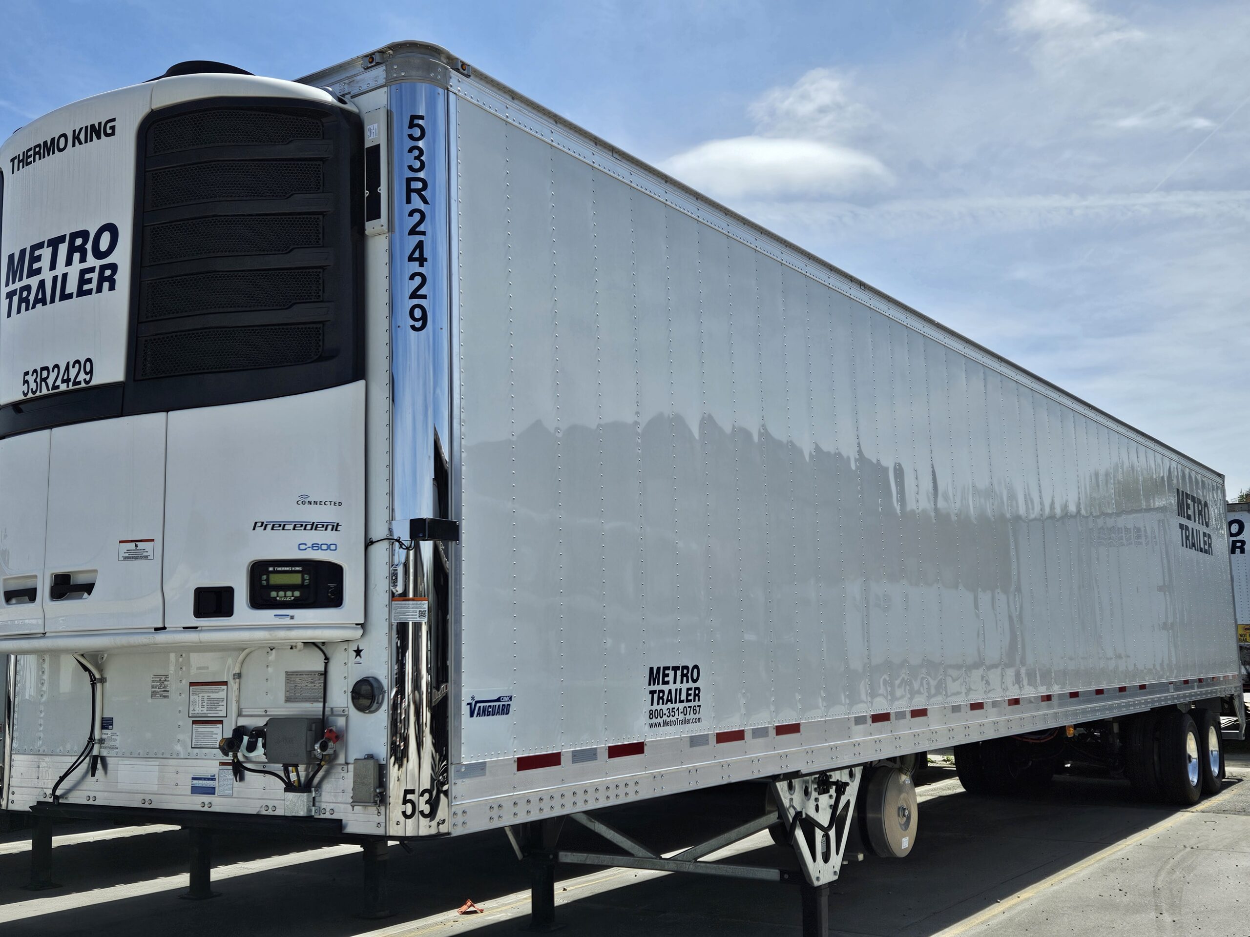 a shiny Metro Trailer refrigerated semi-trailer with a Thermo King unit parked outdoors beneath a blue sky.